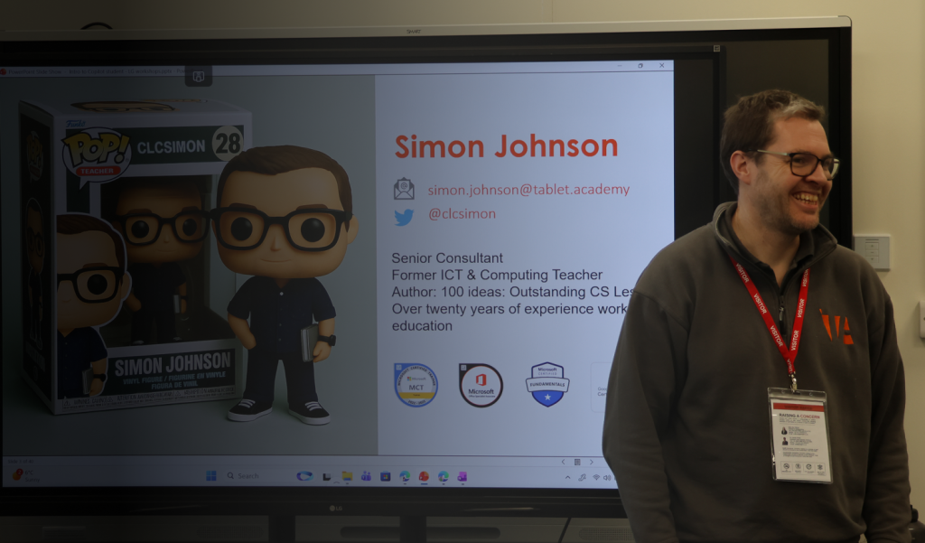 Consultant delivering a workshop at a school stood in front of a screen